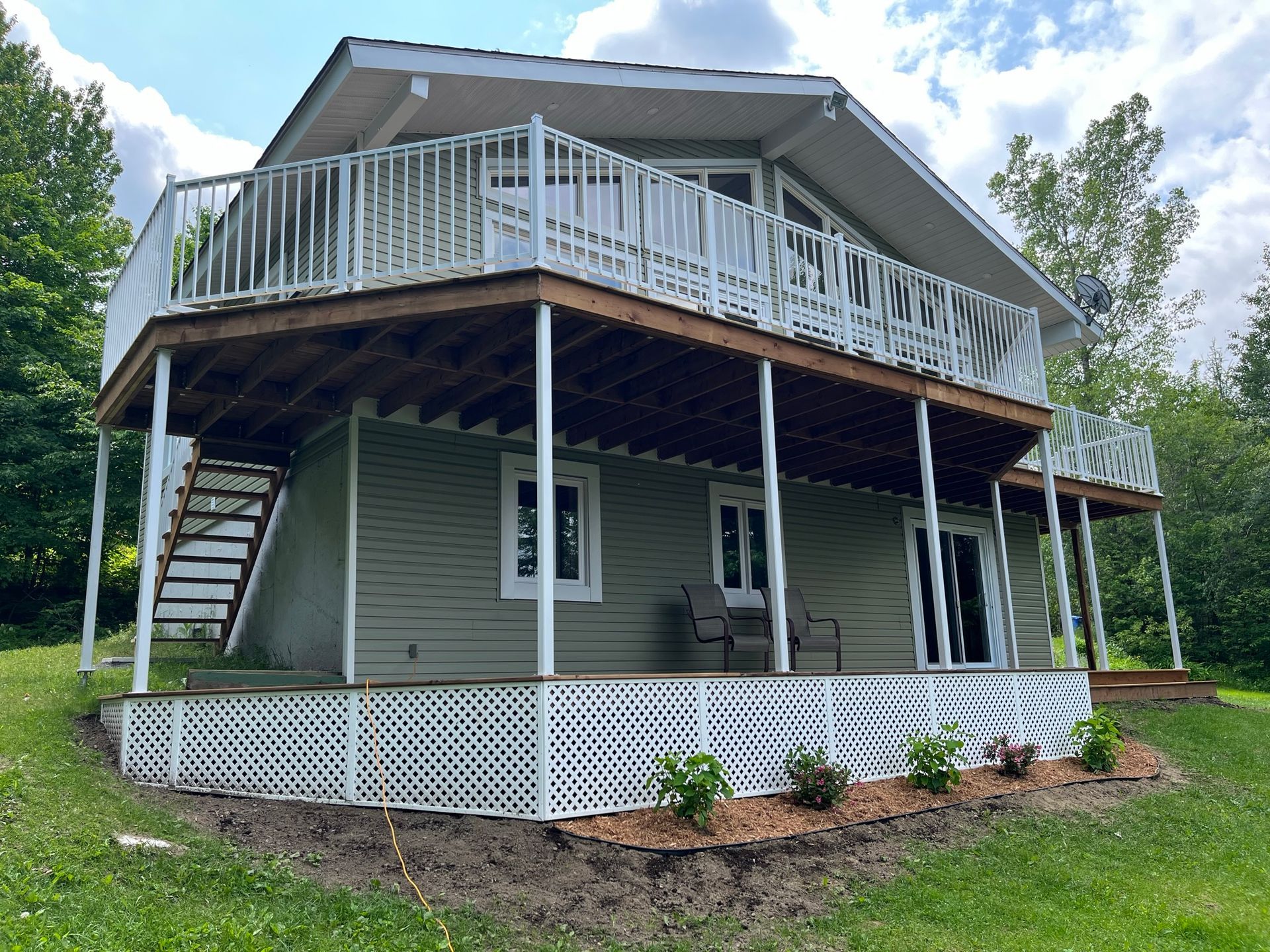 Une maison avec une grande terrasse et des escaliers
