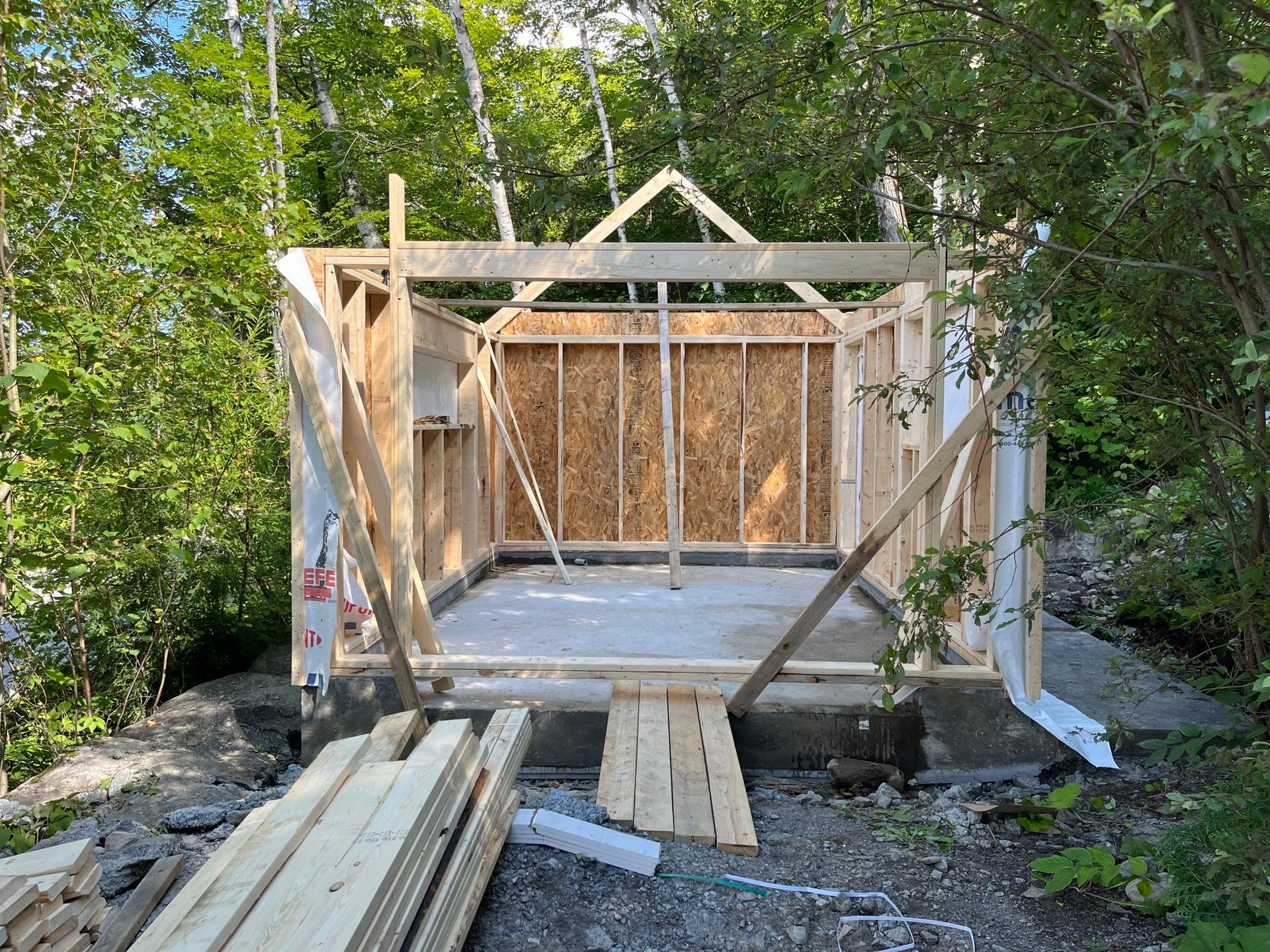 Une structure en bois est en cours de construction dans les bois.