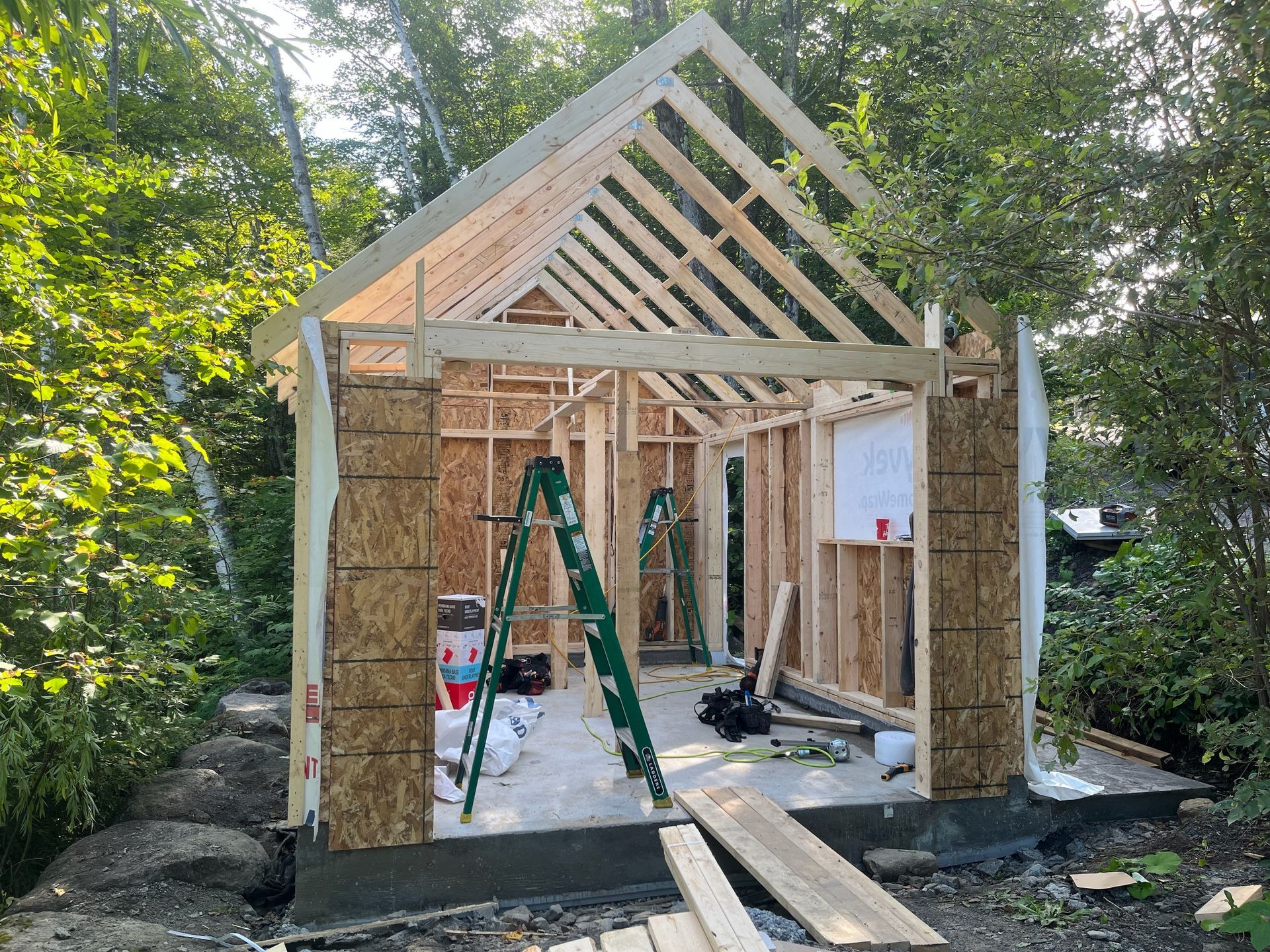 Un cabanon est en cours de construction dans la cour avec une échelle.