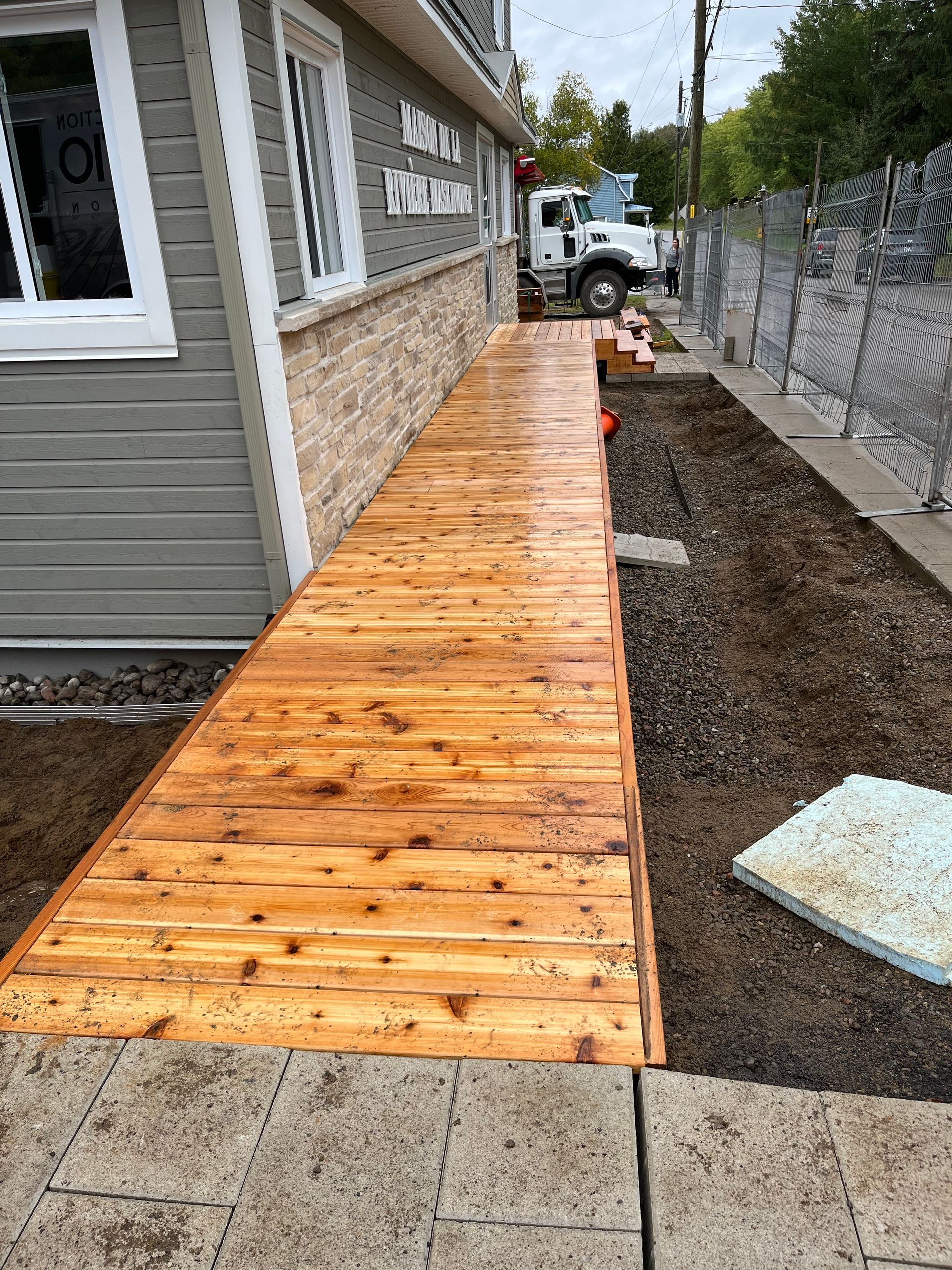 Une passerelle en bois est en cours de construction devant une maison.