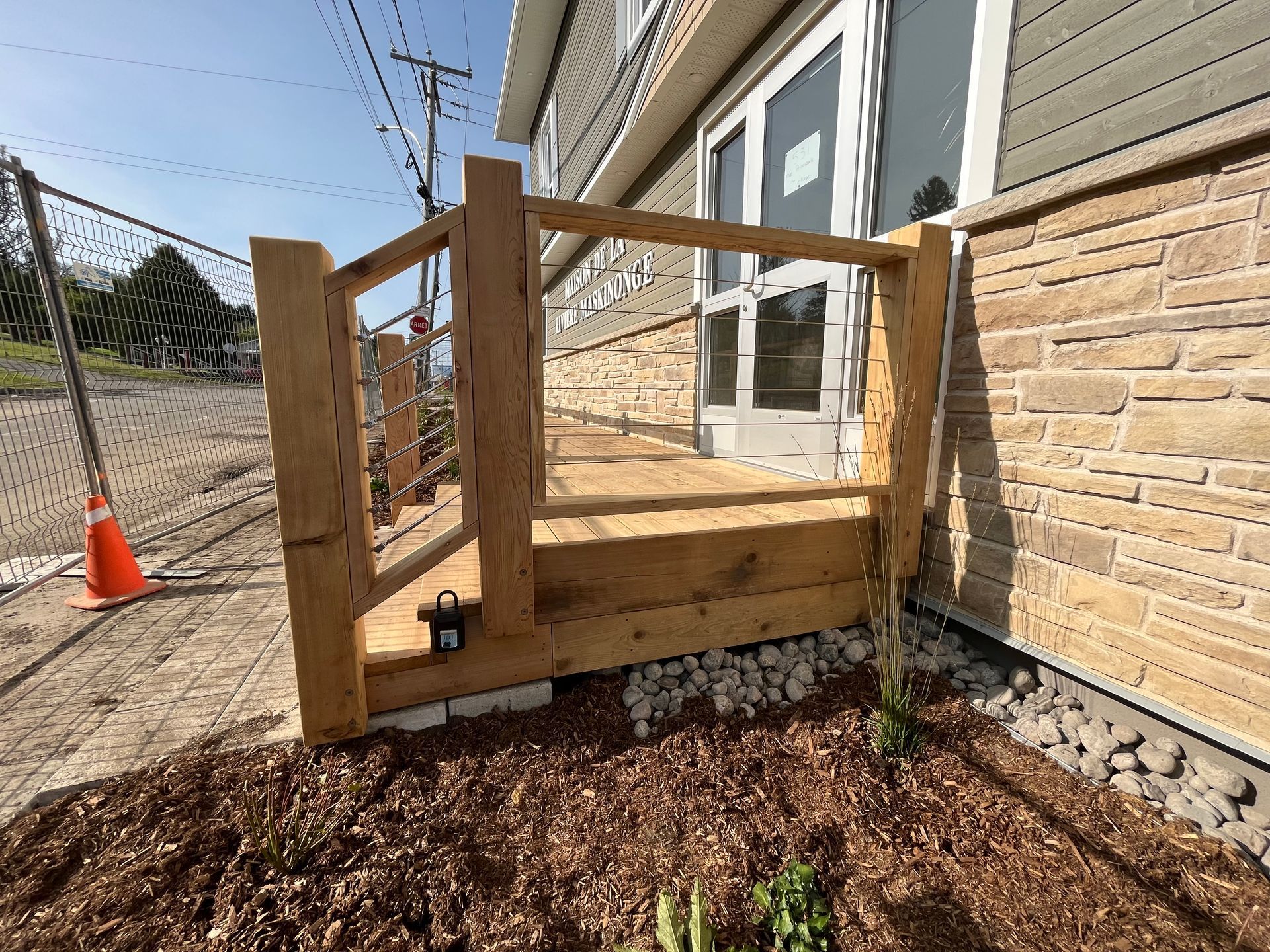 Une terrasse en bois est en cours de construction devant un bâtiment.