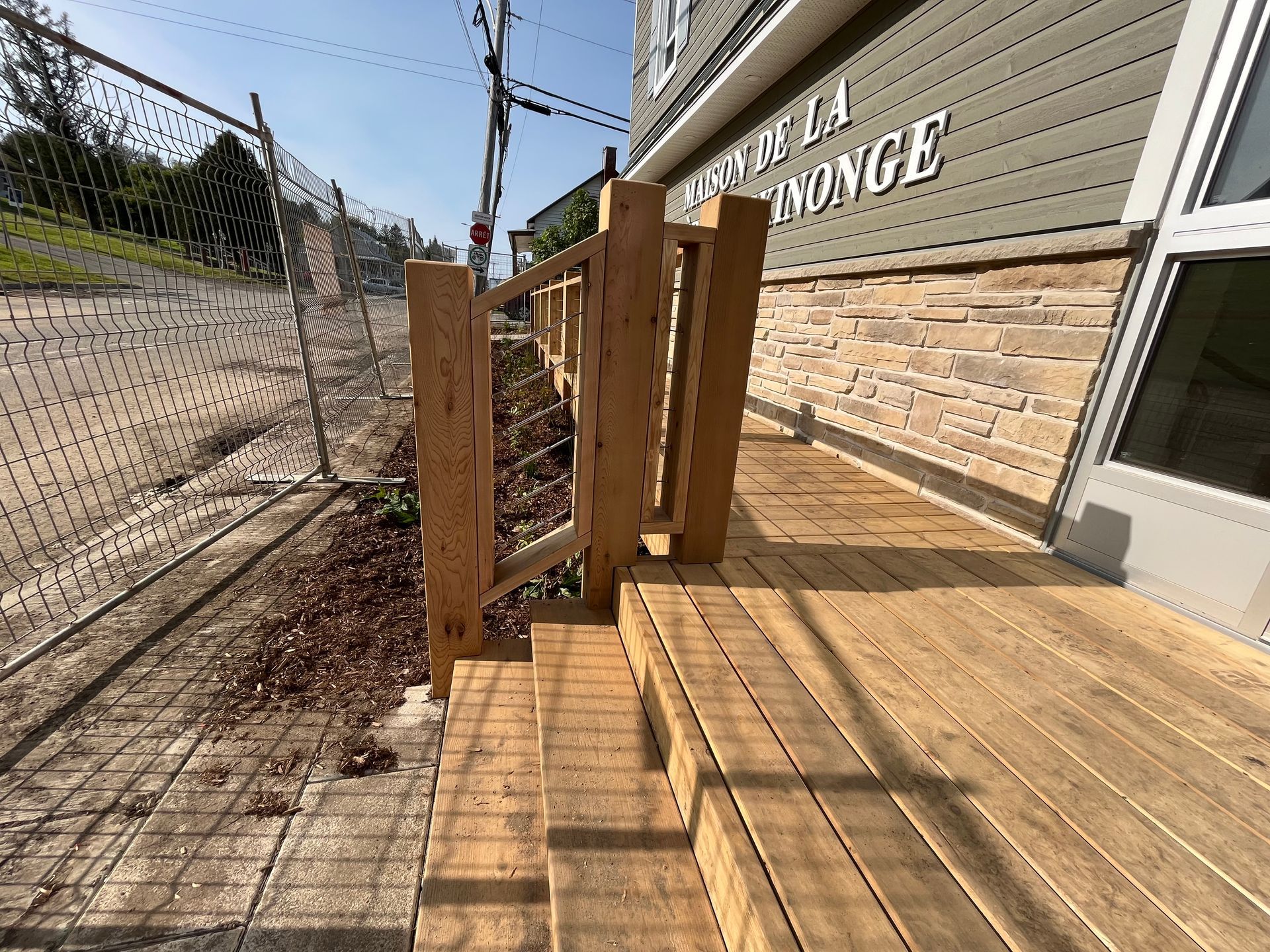 Une terrasse en bois avec des escaliers menant à un bâtiment.