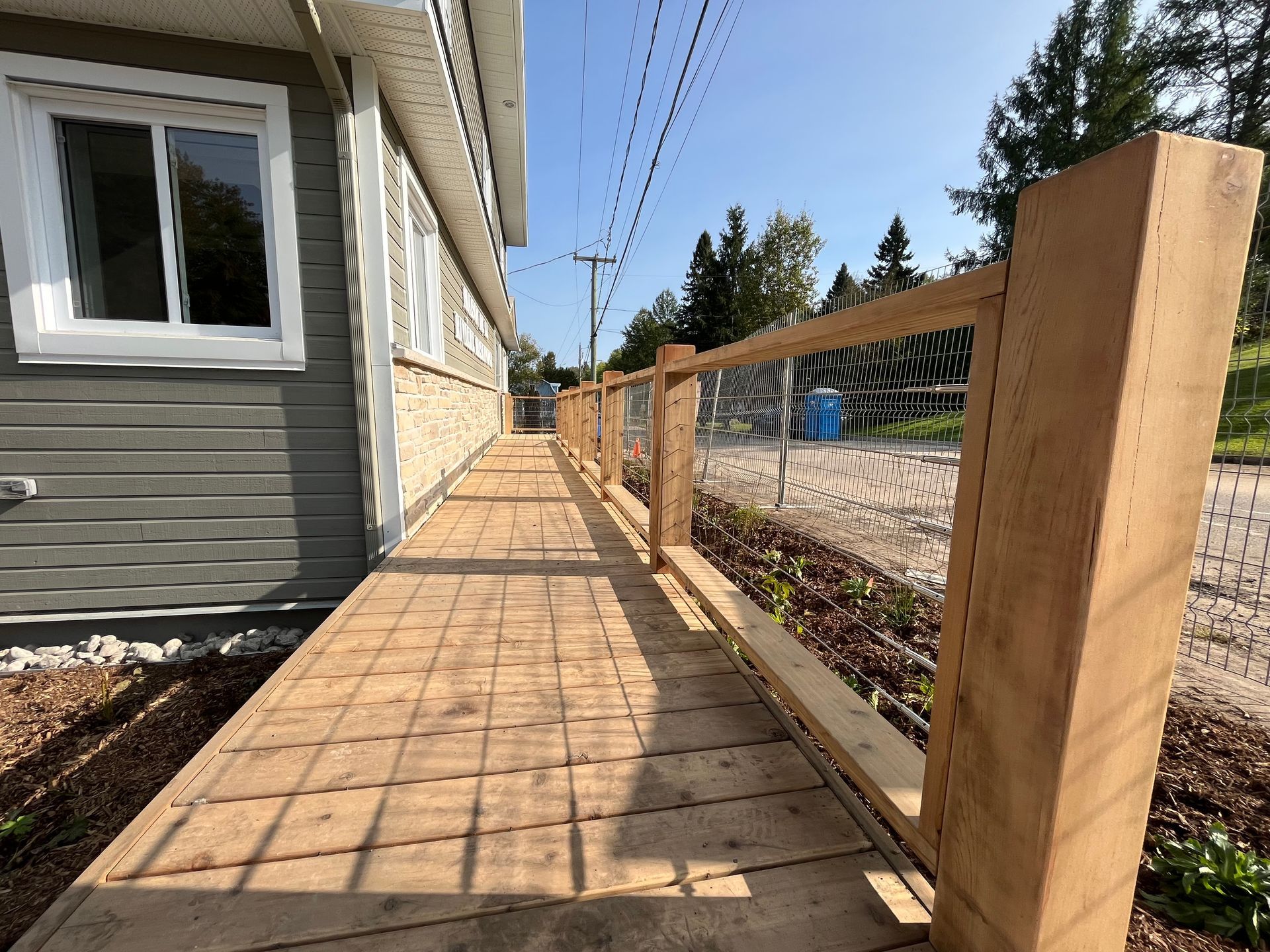 Une passerelle en bois menant à une maison avec une clôture en bois