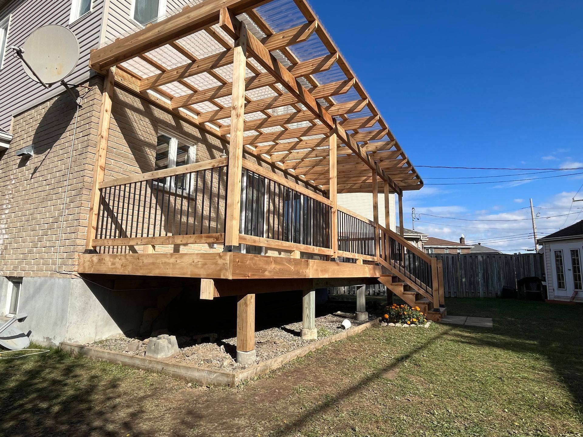 Une terrasse en bois est en cours de construction dans la cour d'une maison.