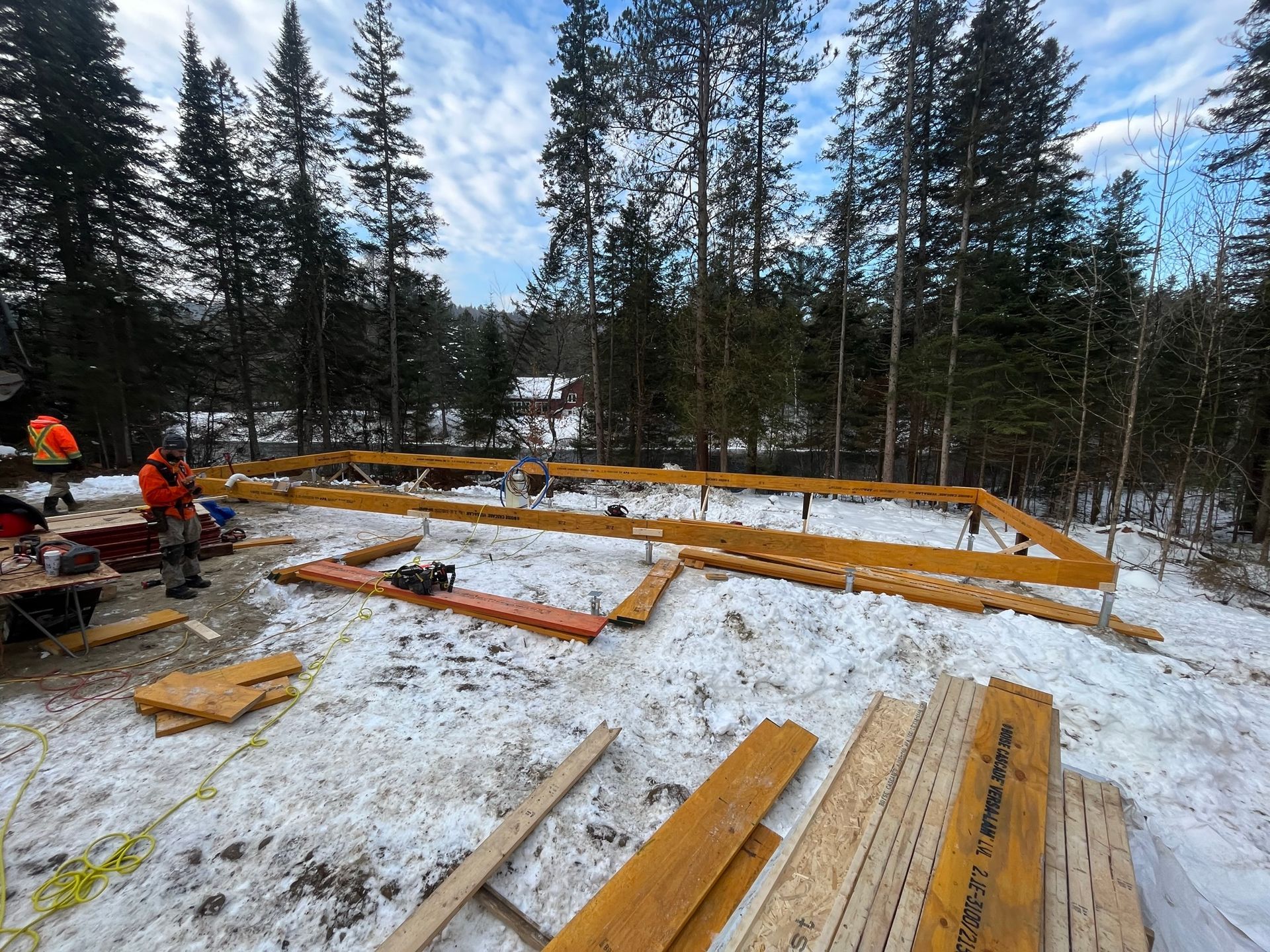Un groupe de personnes travaille sur une structure en bois dans la neige.