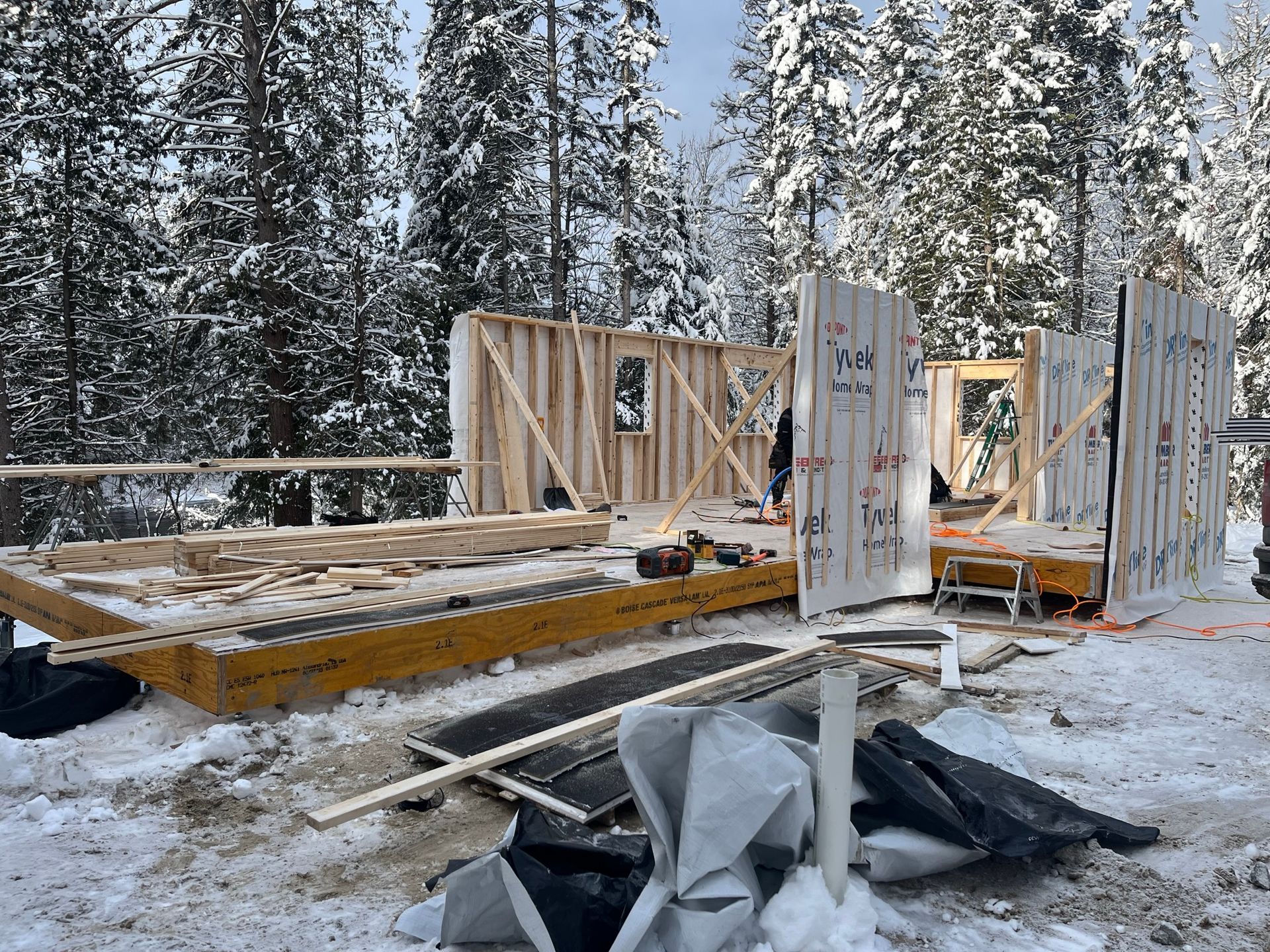 Une maison est en construction dans la neige dans les bois.