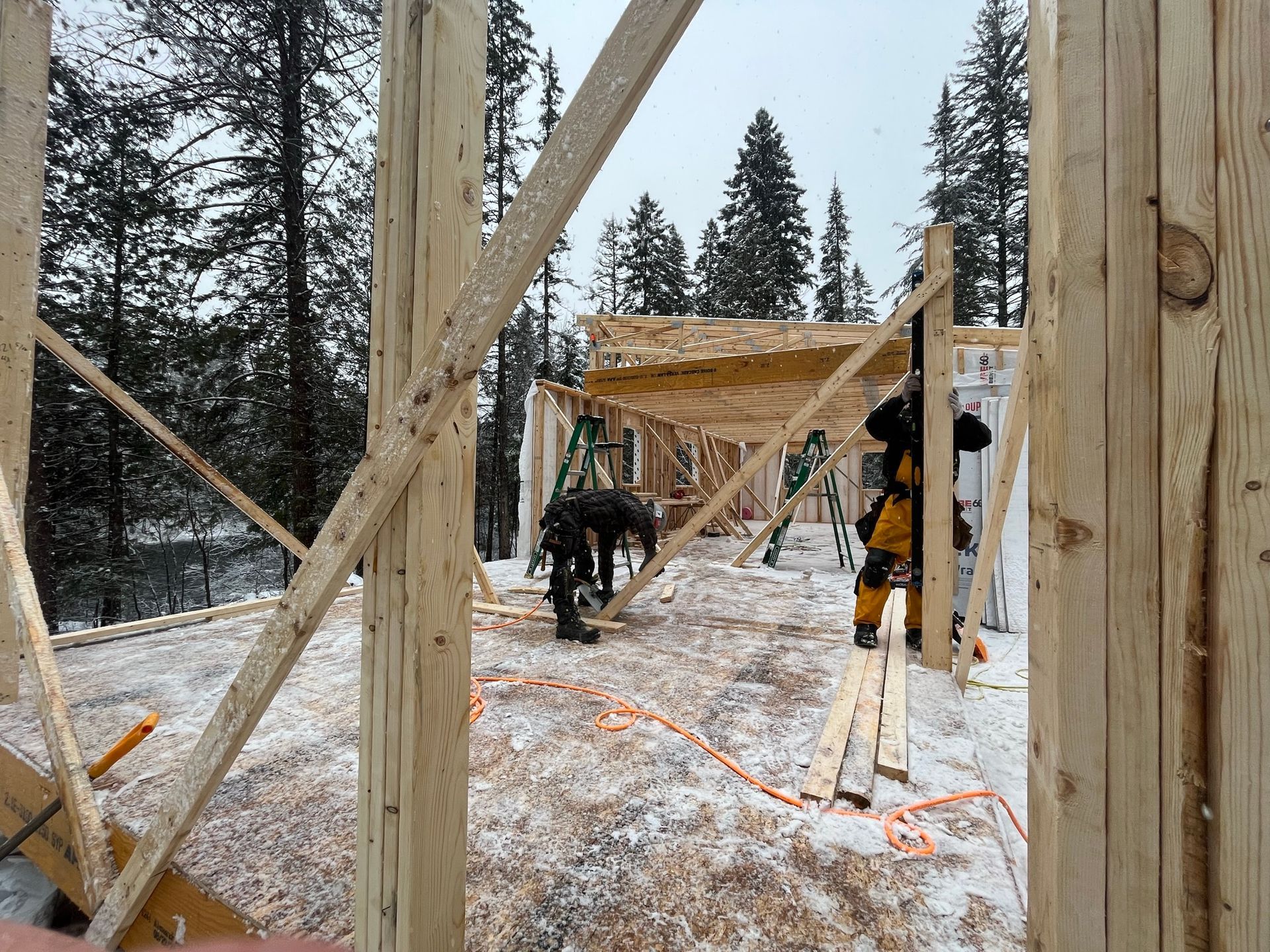 Un groupe de personnes travaille sur une structure en bois dans la neige.