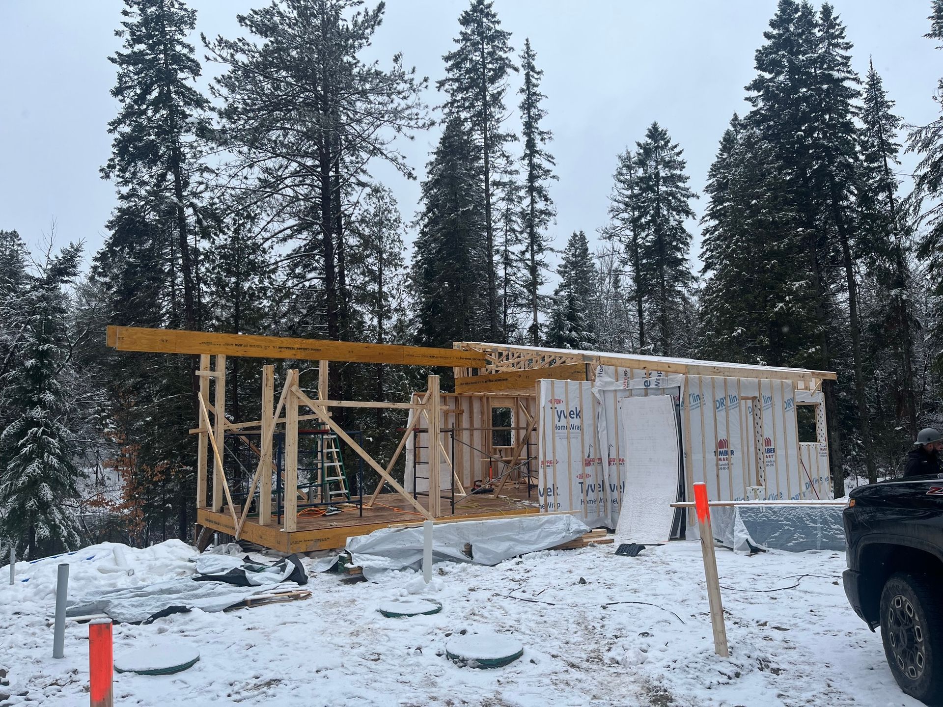 Un camion est garé devant une maison en construction dans la neige.