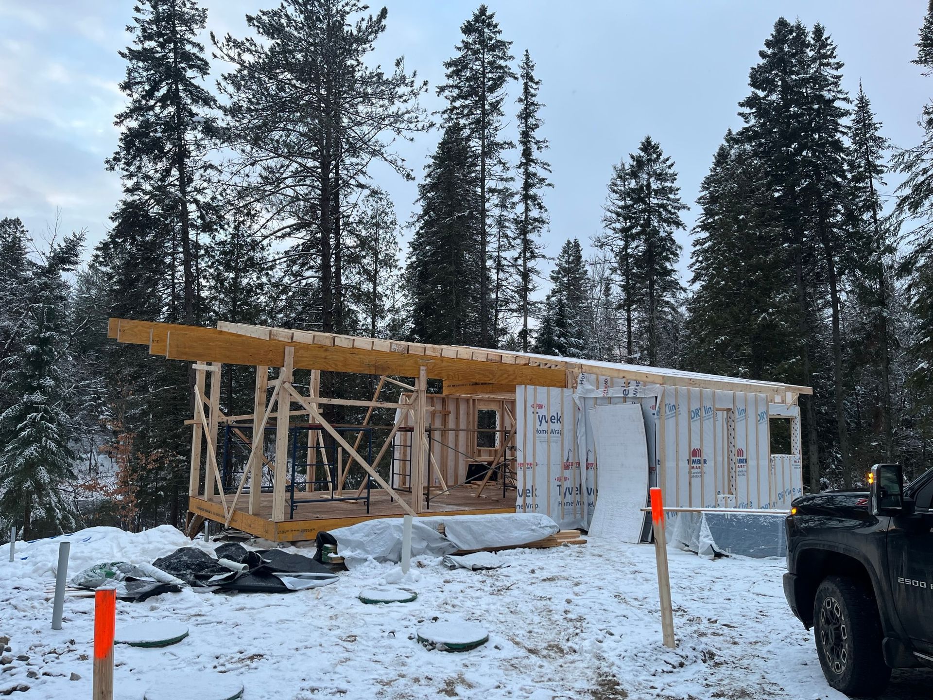 Un camion est garé devant une maison en construction dans la neige.
