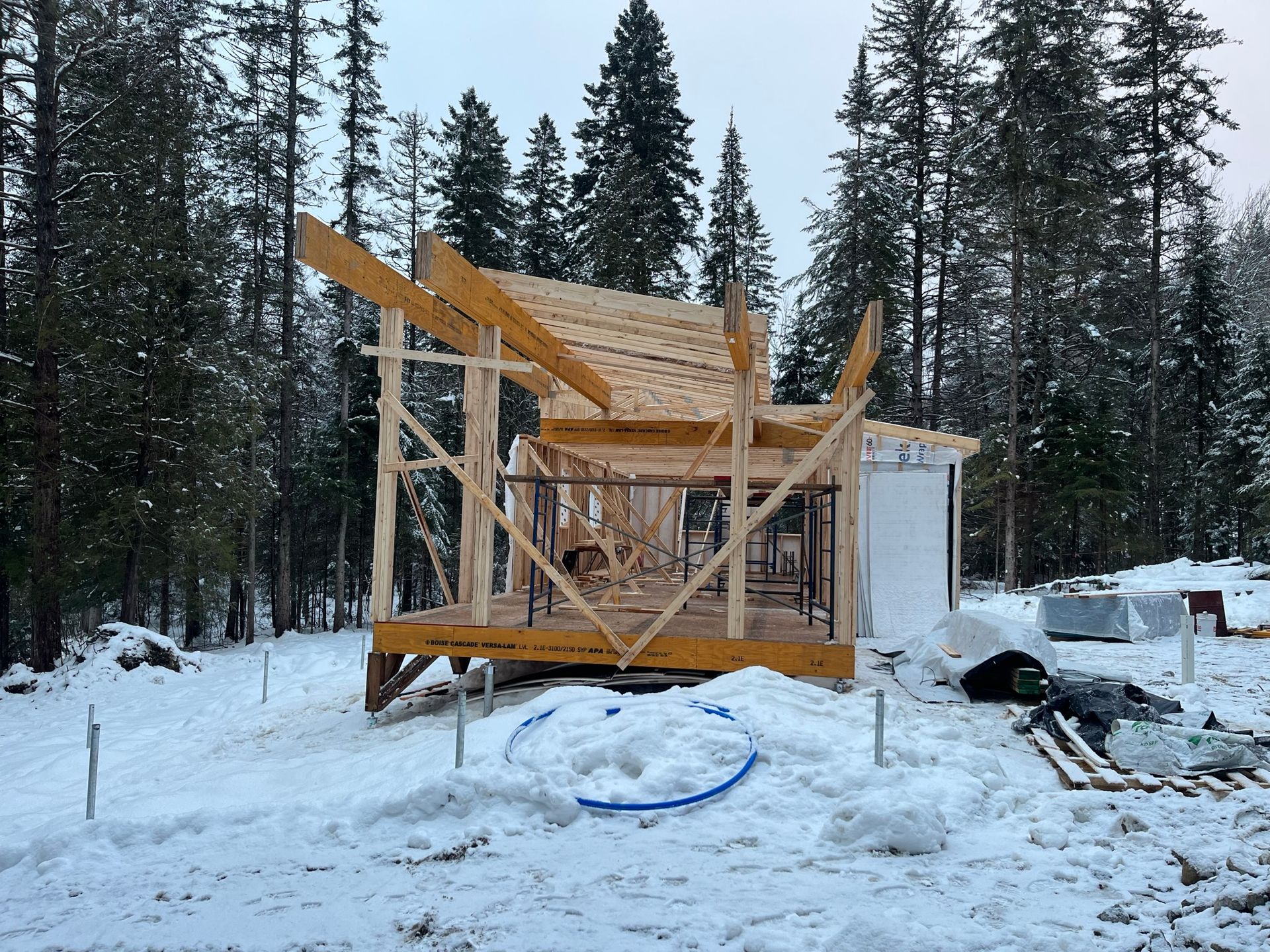 Une structure en bois est en train d'être construite dans la neige au milieu d'une forêt.