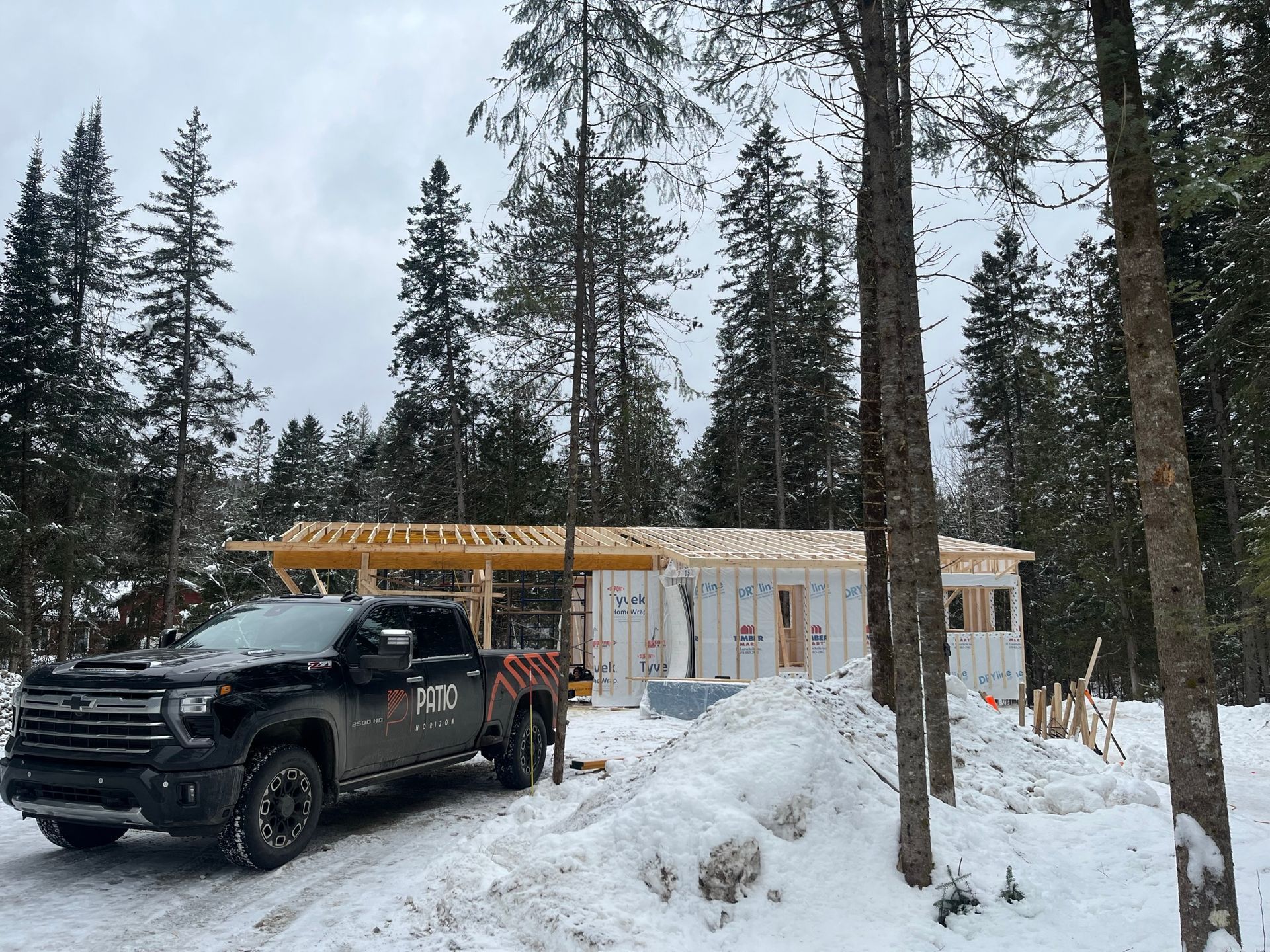 Un camion est garé devant une maison en construction dans la neige.