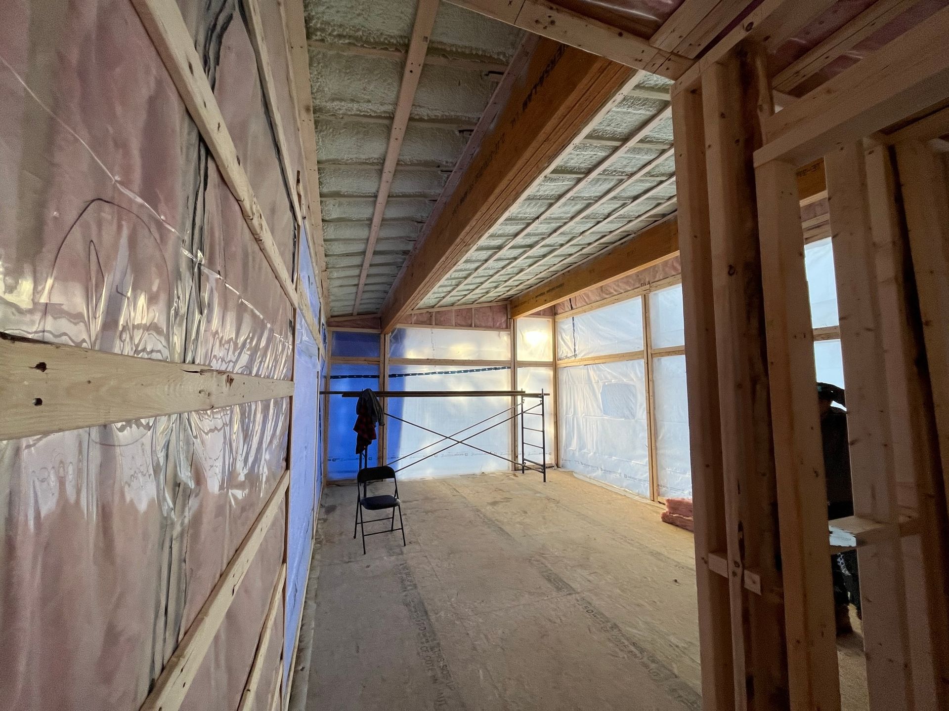 Un long couloir dans un immeuble en construction avec une échelle.