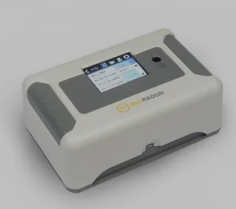 White and gray tabletop device with a small touchscreen display and dark side grips.