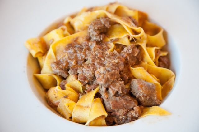 Pappardelle al ragù in una ciotola bianca.