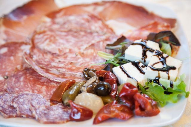 Piatto di salumi con affettati, formaggio, olive e peperoni arrostiti.