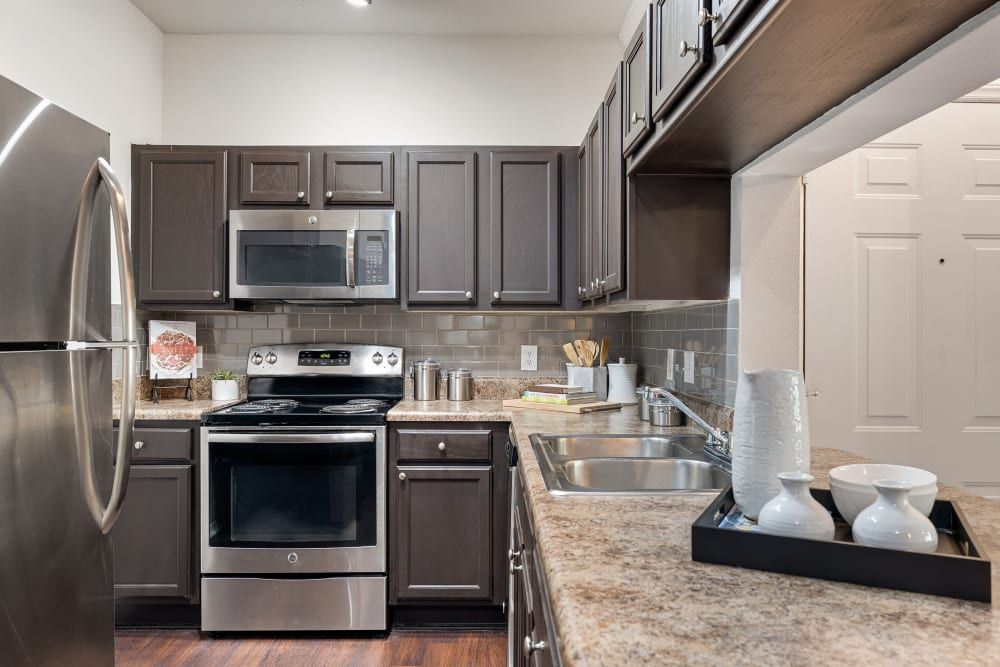 a kitchen with stainless steel appliances and granite counter tops at Marquis Carmel Valley in Charlotte, NC.