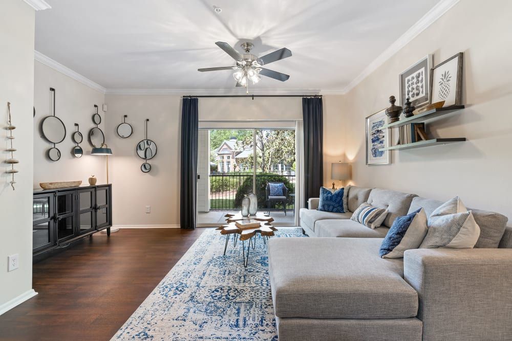 a living room with a couch and a ceiling fan at Marquis Carmel Valley in Charlotte, NC.