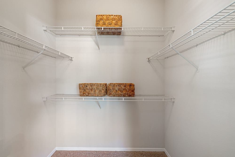a walk-in closet with lots of shelves and baskets at Marquis Carmel Valley in Charlotte, NC.