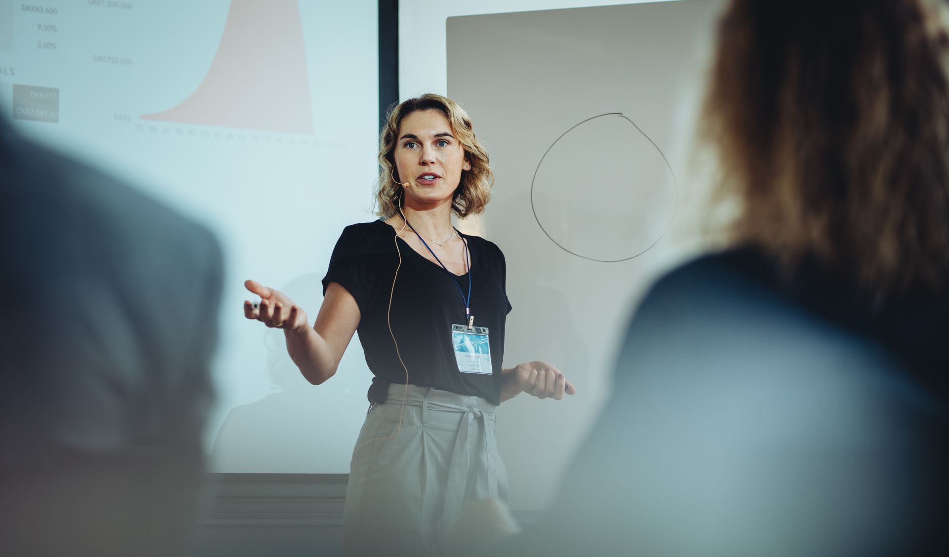 Une femme fait une présentation à un groupe de personnes.