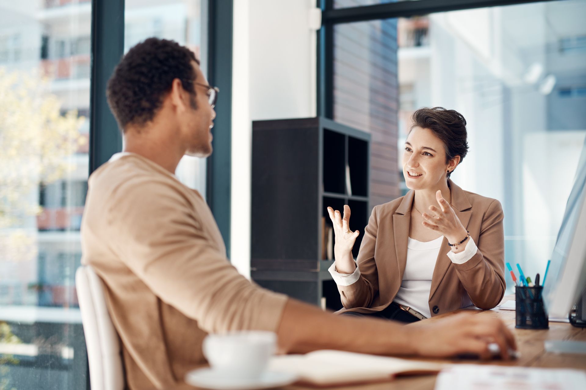 Un homme et une femme sont assis à un bureau et discutent.