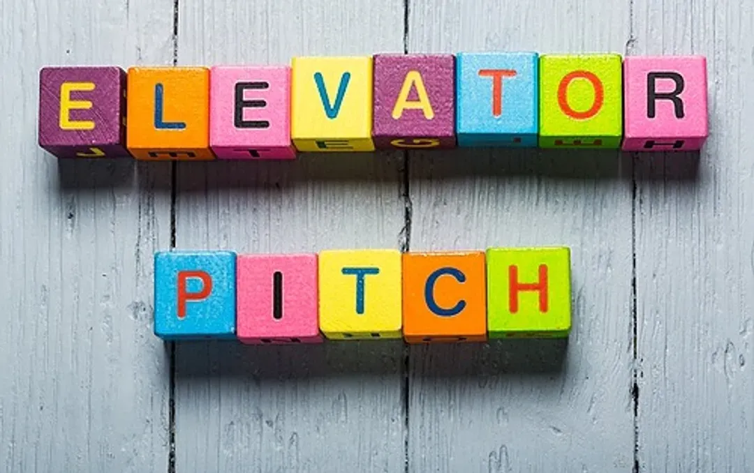 Le mot « lift pitch » est écrit avec des blocs de bois colorés sur une table en bois.