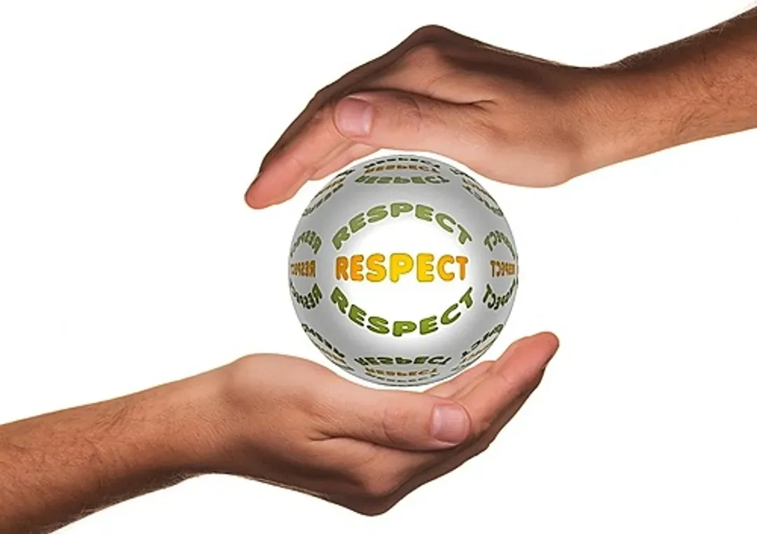 Deux mains tenant une balle sur laquelle est écrit « respect »