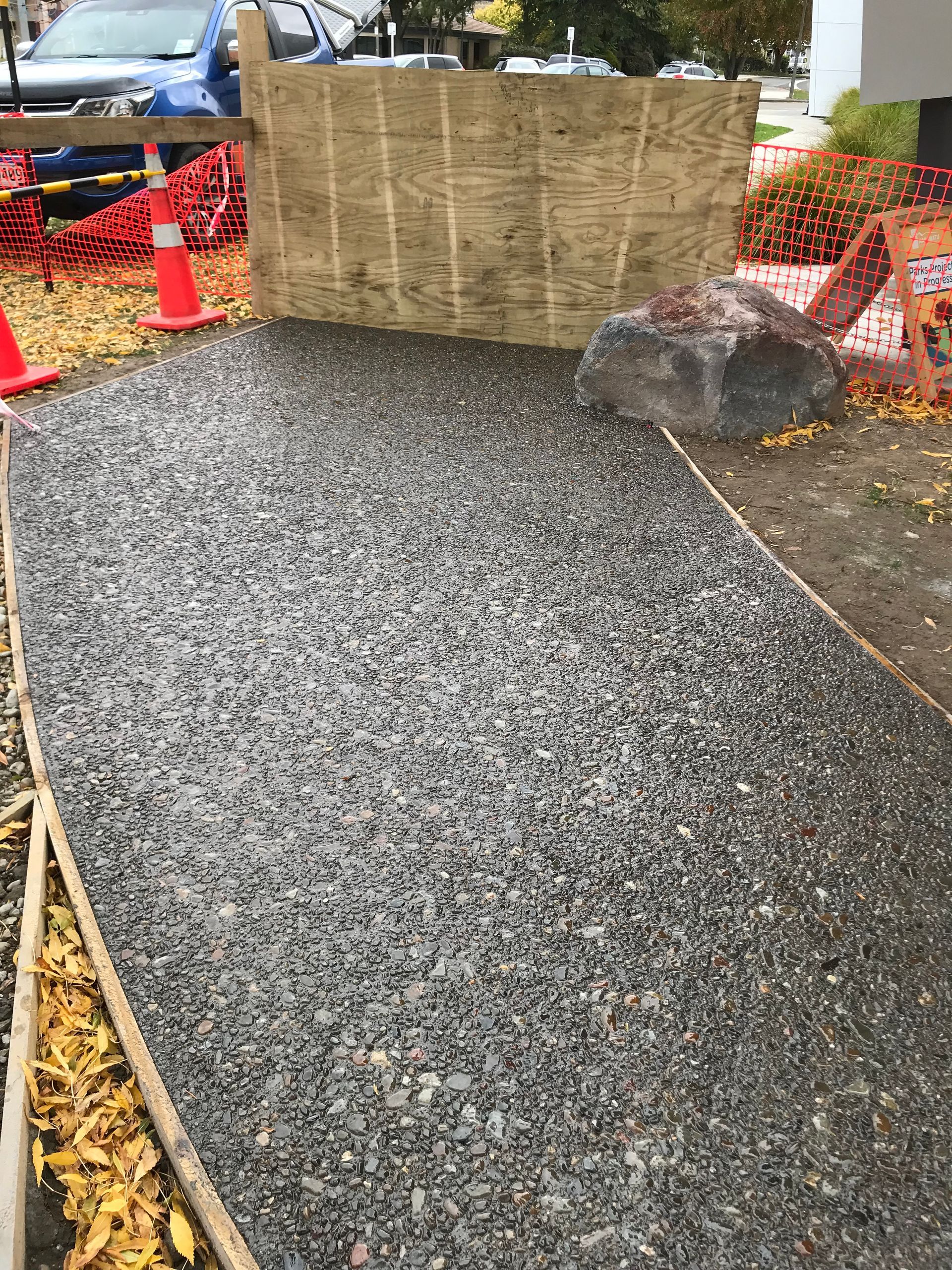 A large rock is sitting on top of a gravel path.