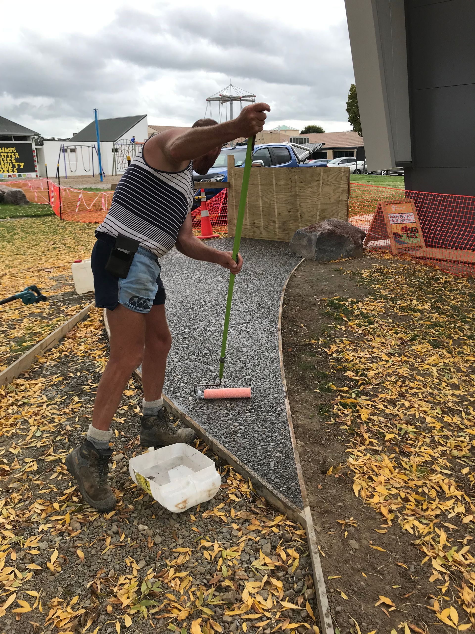 A man is sweeping the ground with a broom.