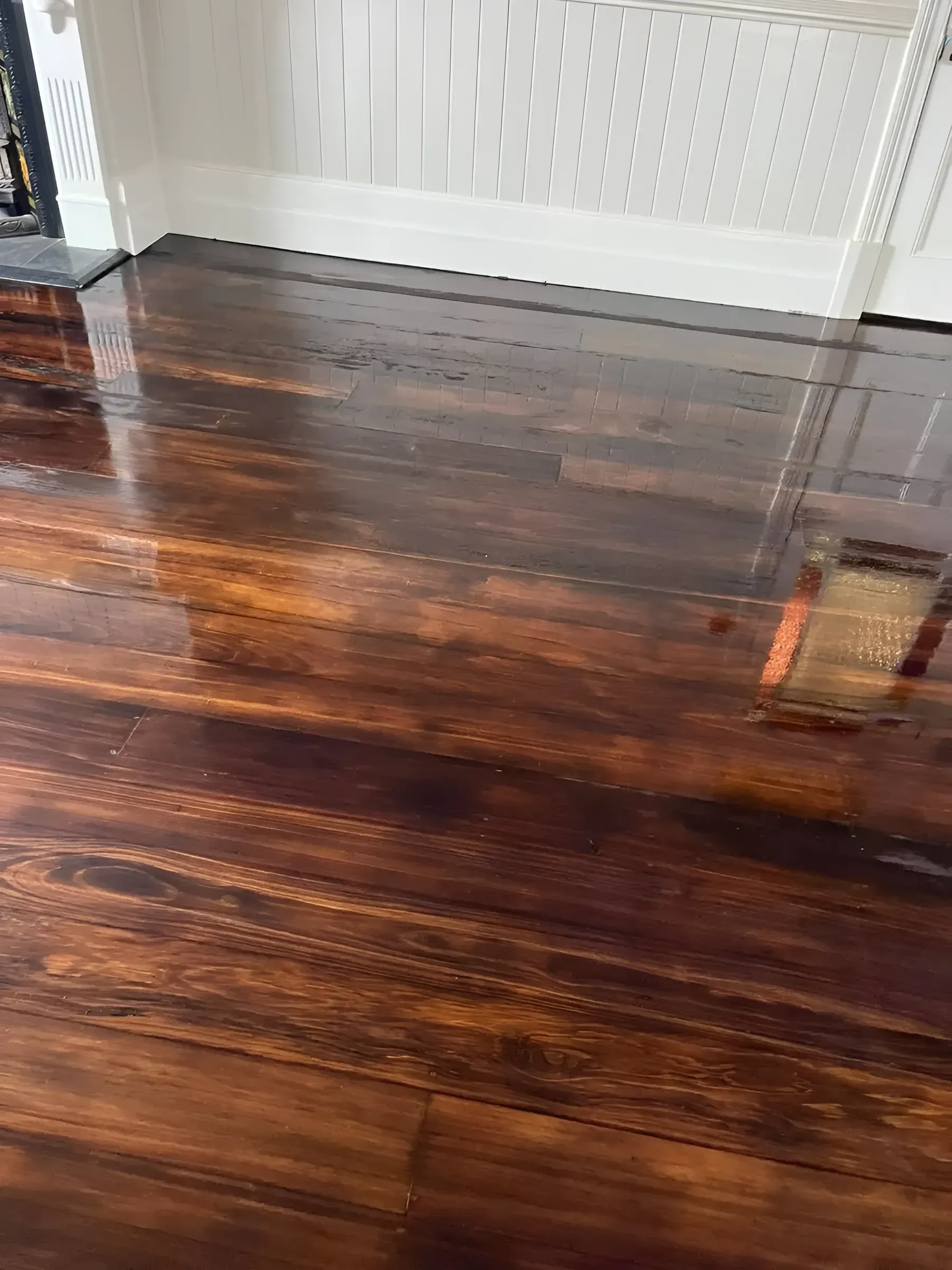 Shiny Dark Wood-Look Floor Reflecting Light a White Baseboard — Toowoomba Polished Floors in Murphy's Creek, QLD