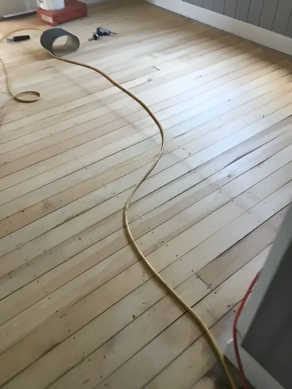 Yellow Extension Cord Snaking Across Sanded Wooden Floor — Toowoomba Polished Floors in Toowoomba, QLD