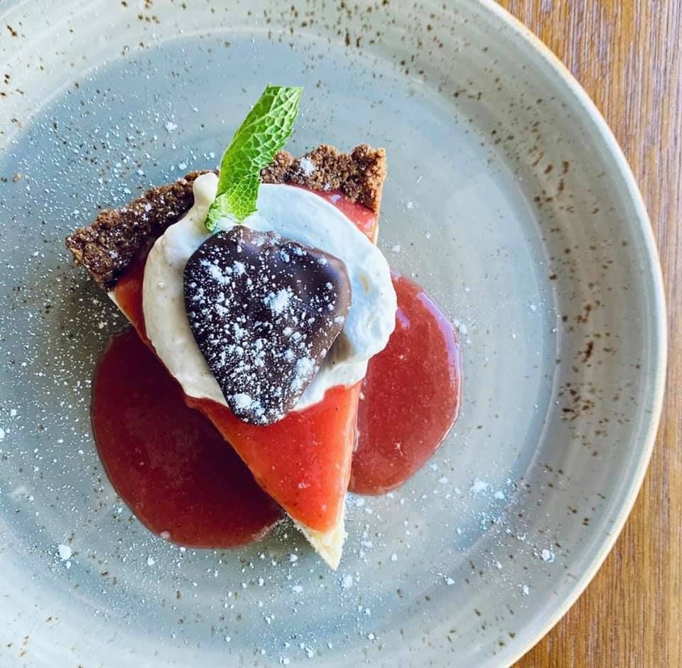 A slice of pie on a plate with sauce