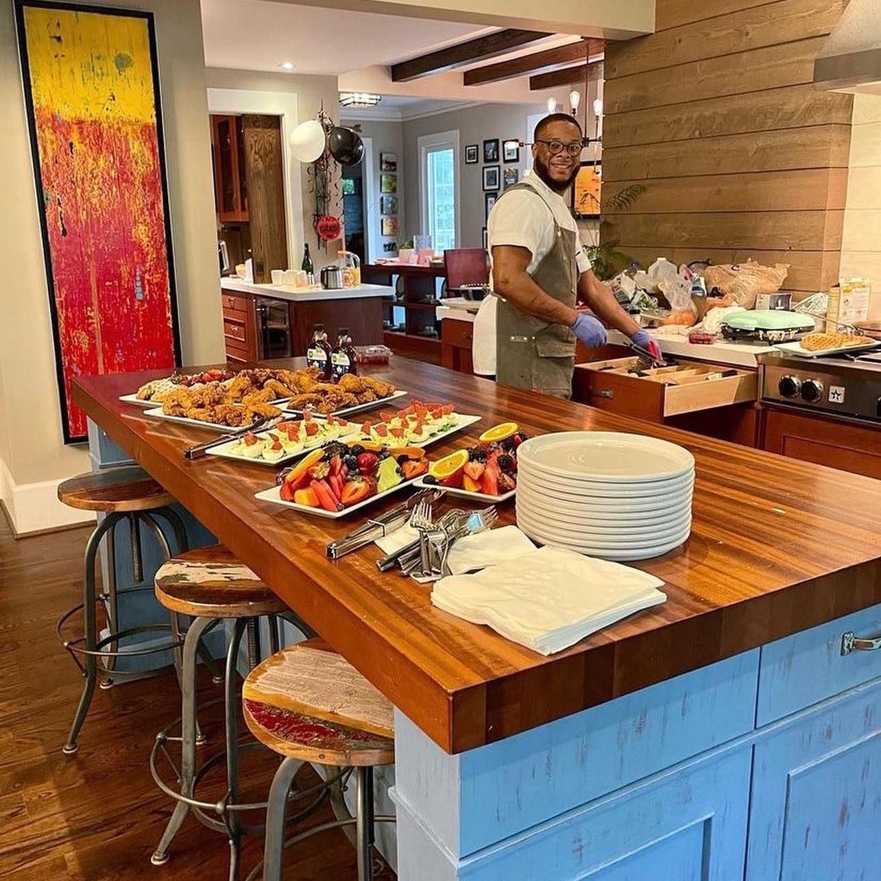 Chef Senoj preparing food on a wooden table in a kitchen