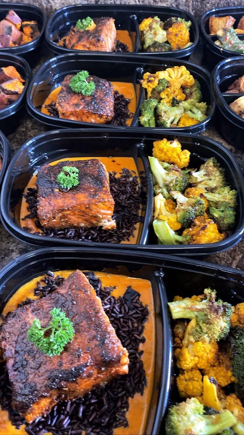 A variety of healthy meals in plastic containers are sitting on a table.