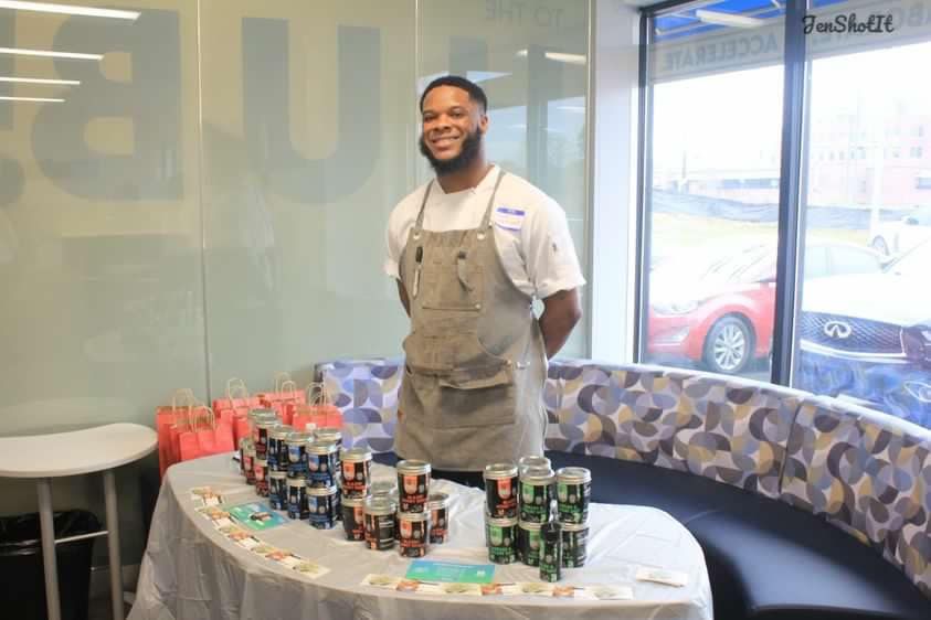 Chef Senoj standing in front of a table with spices on it.