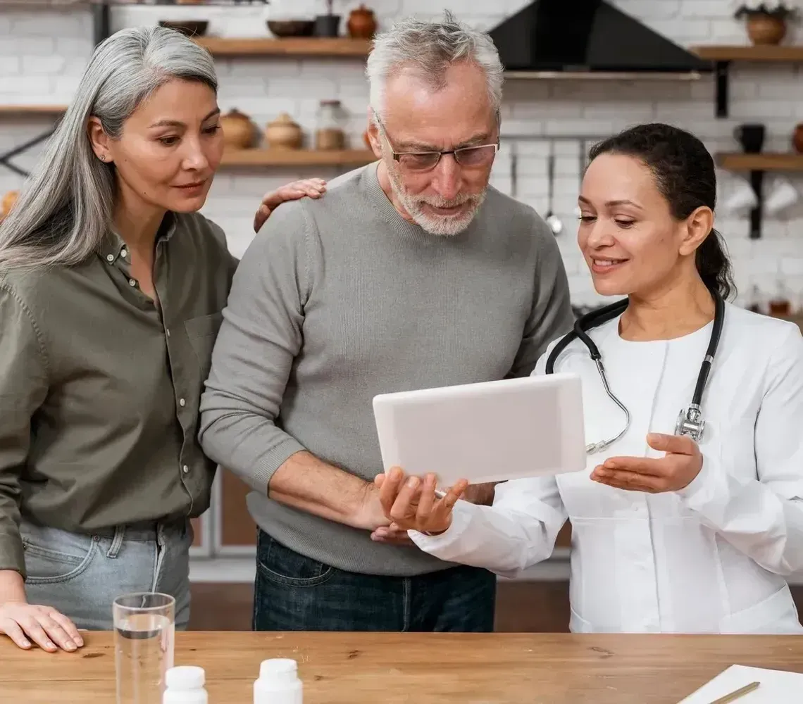 Three people reviewing a document together at a table in a bright kitchen.