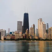 Chicago skyline with Lake Michigan in the foreground at dusk, centered on the John Hancock Tower