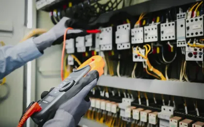 Service of Knights LLC - An electrician is working on an electrical panel with a multimeter.