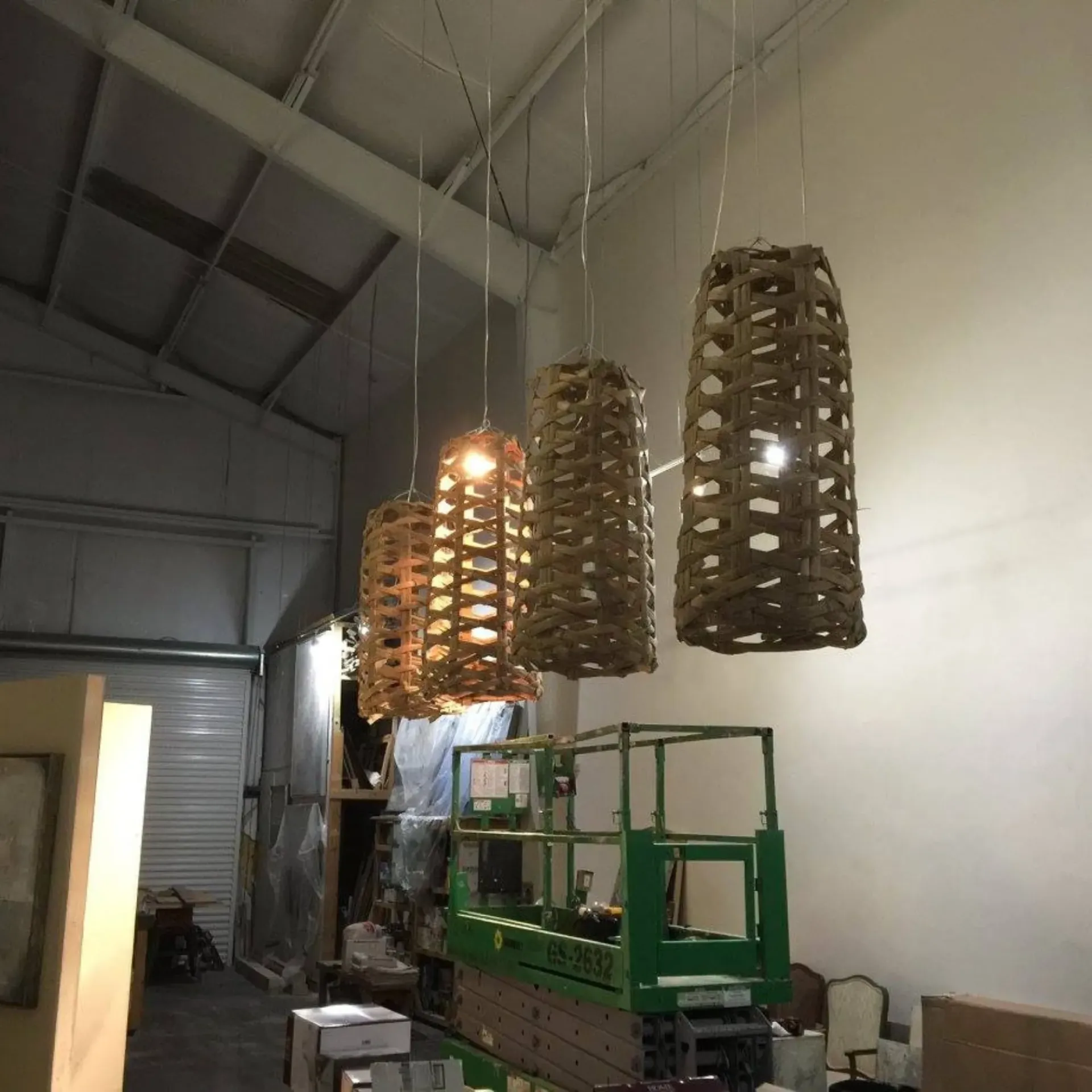 Service of Knights LLC - A warehouse with a green crane and wicker lamps hanging from the ceiling