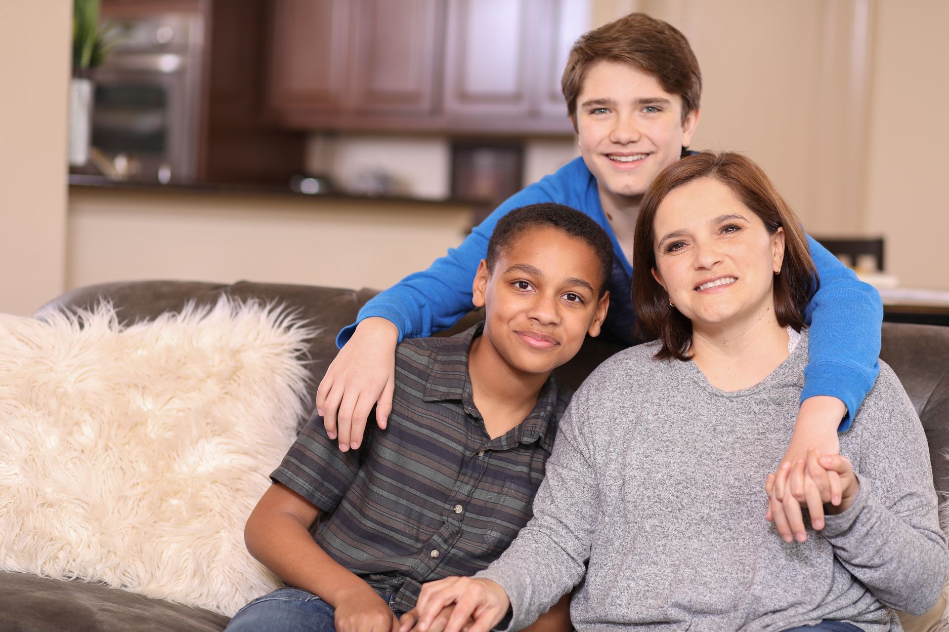 A family is posing for a picture while sitting on a couch.