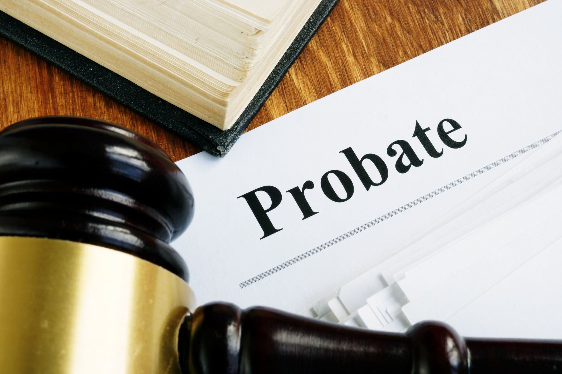 A wooden gavel is sitting on top of a piece of paper that says probate.