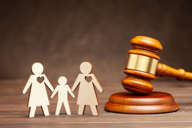 A wooden gavel is sitting on a wooden table next to a wooden family.