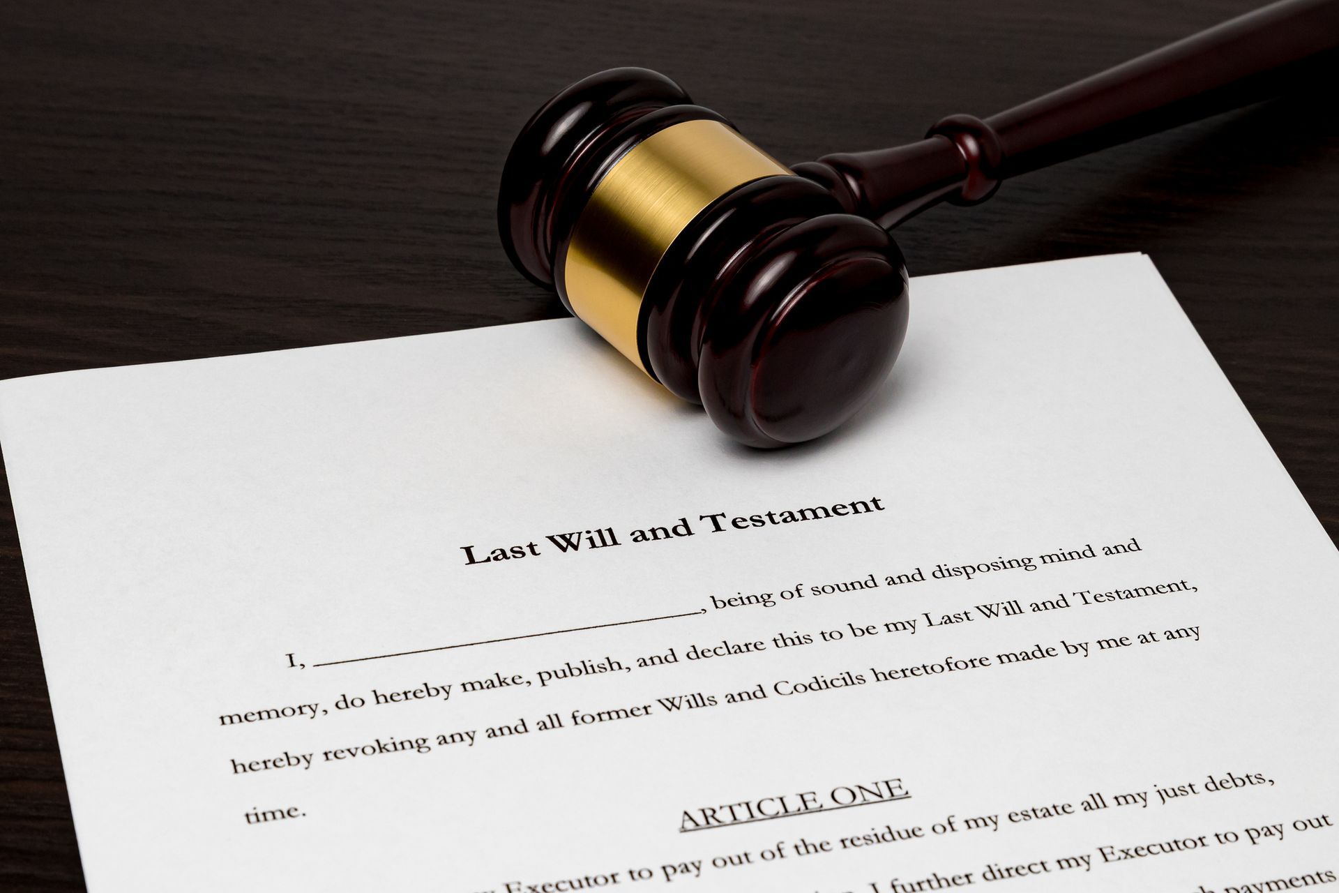 A judge 's gavel is sitting on top of a last will and testament