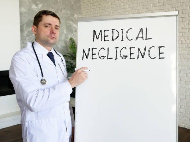 A doctor is pointing at a whiteboard that says medical negligence.
