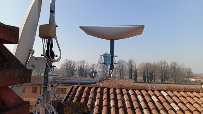 Vista dal tetto di due parabole satellitari. Una è piccola, bianca e di forma rettangolare. L'altra è più grande e rotonda.