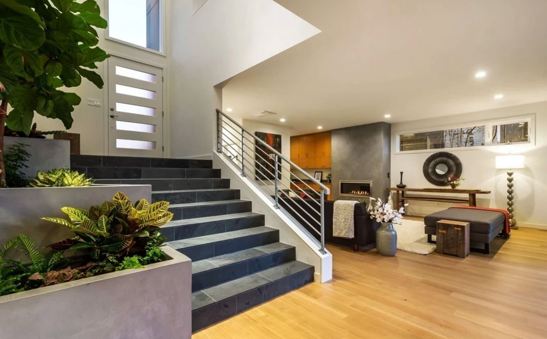 Modern home interior with staircase, hardwood floors, and living room.
