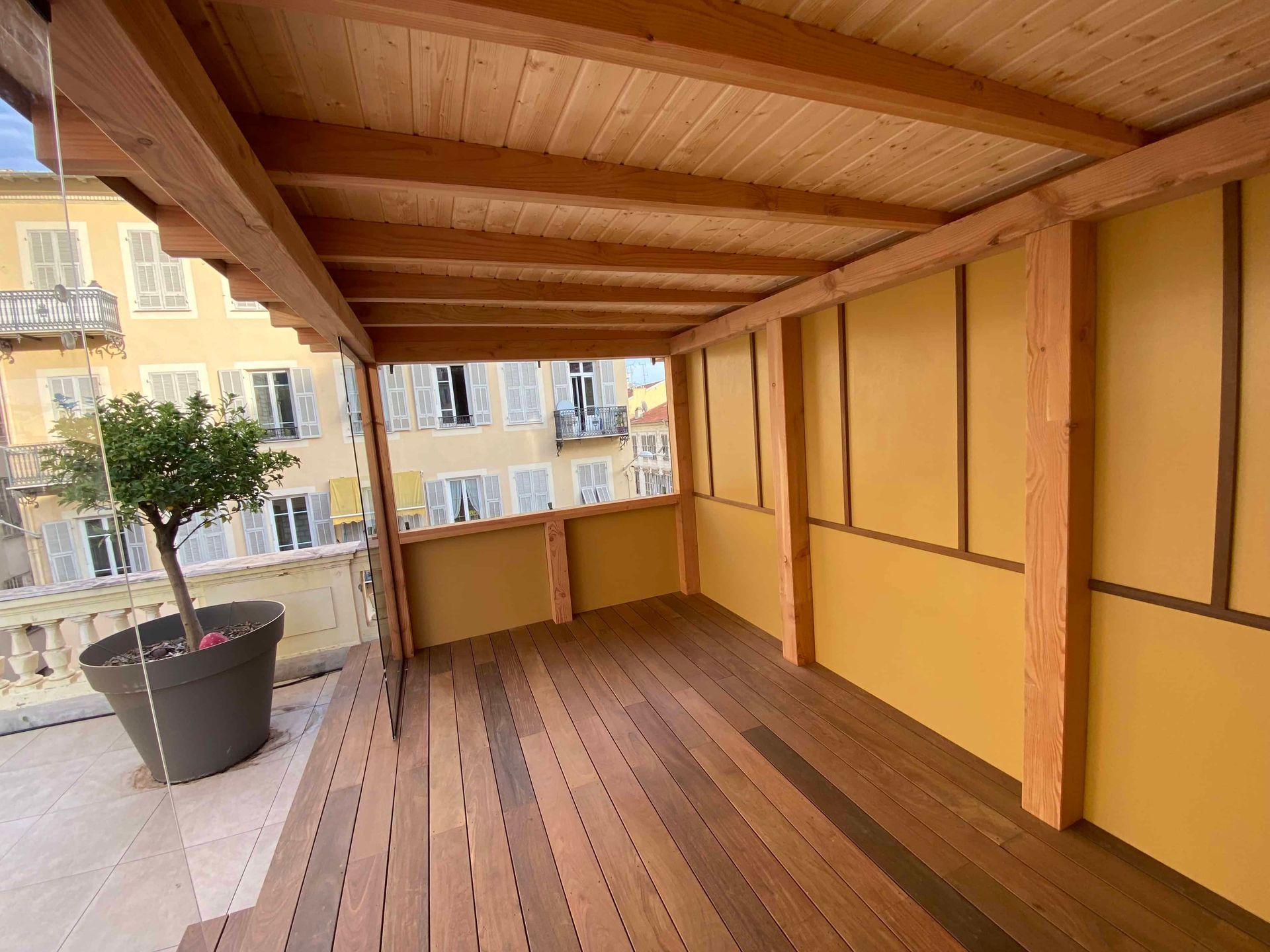 Une terrasse en bois avec une plante en pot dessus