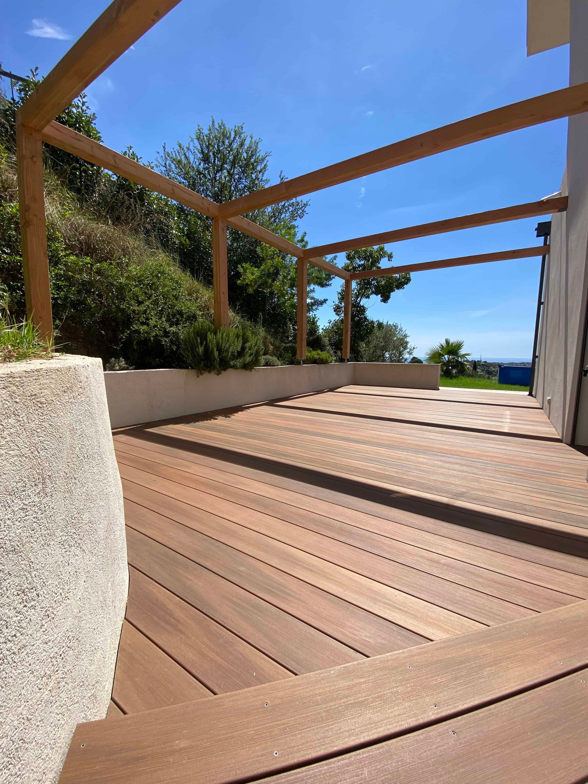Une terrasse en bois avec une pergola au-dessus