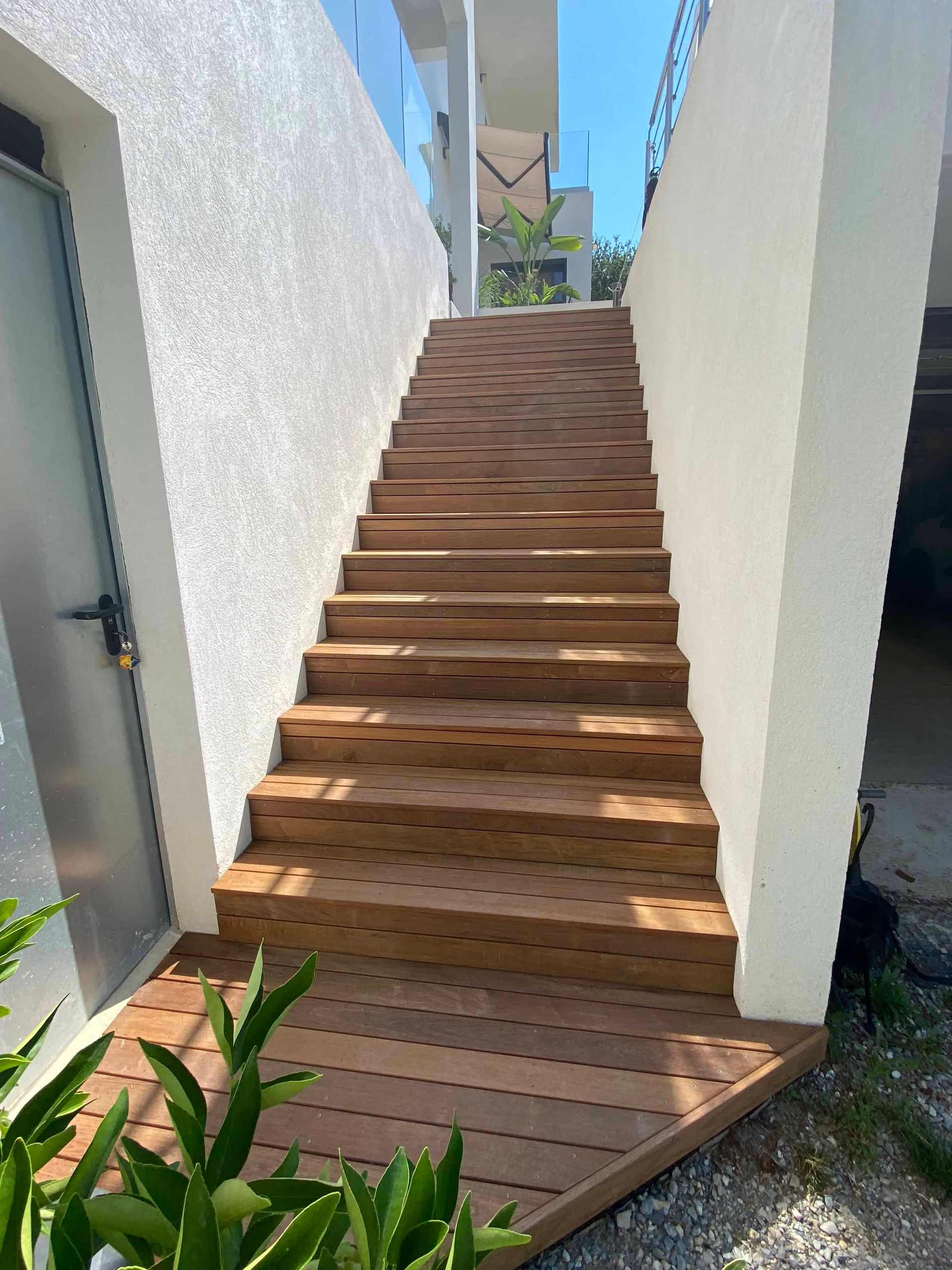 Un escalier en bois menant à un bâtiment blanc.
