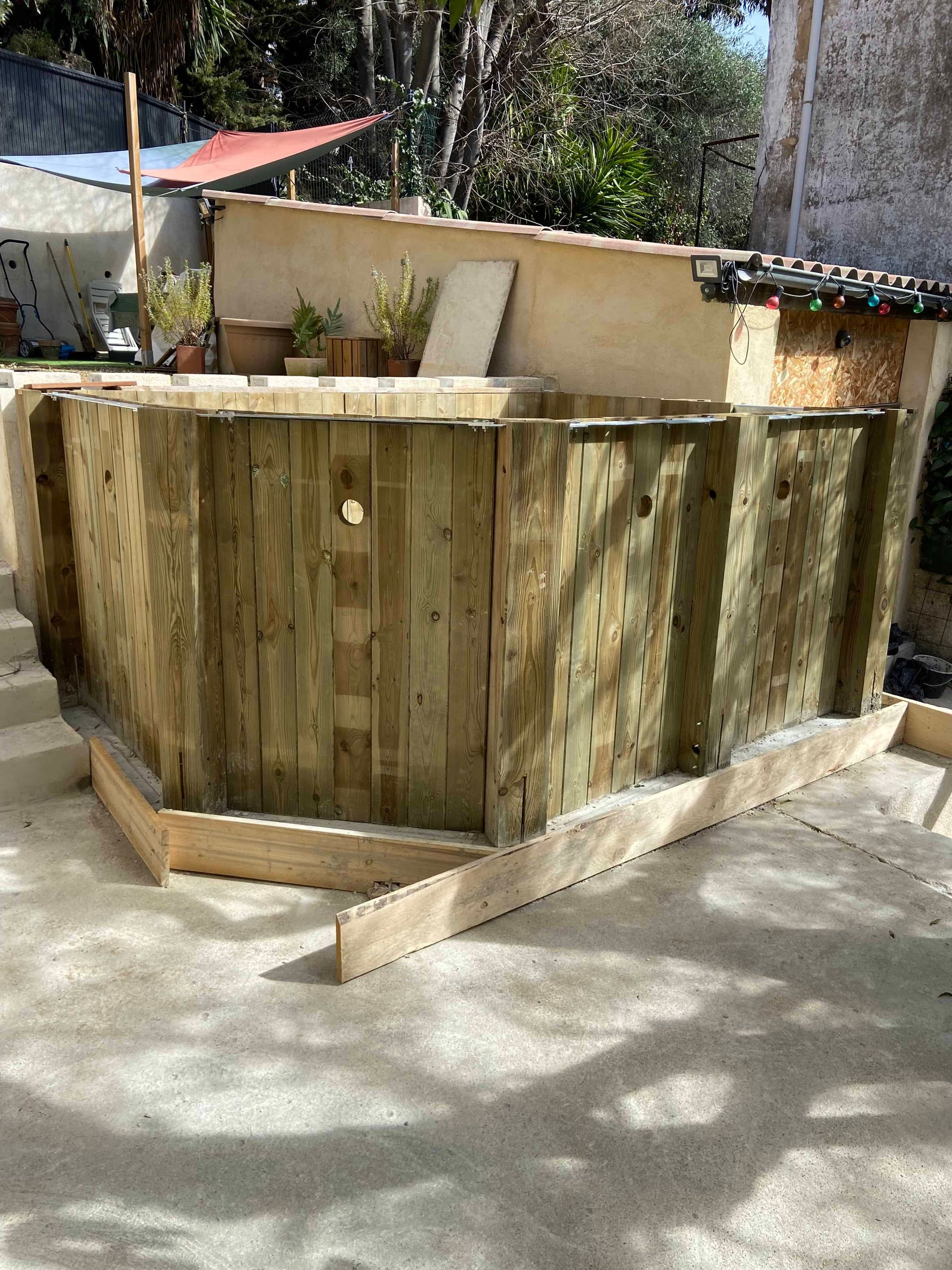 Une clôture en bois est en cours de construction dans une cour.