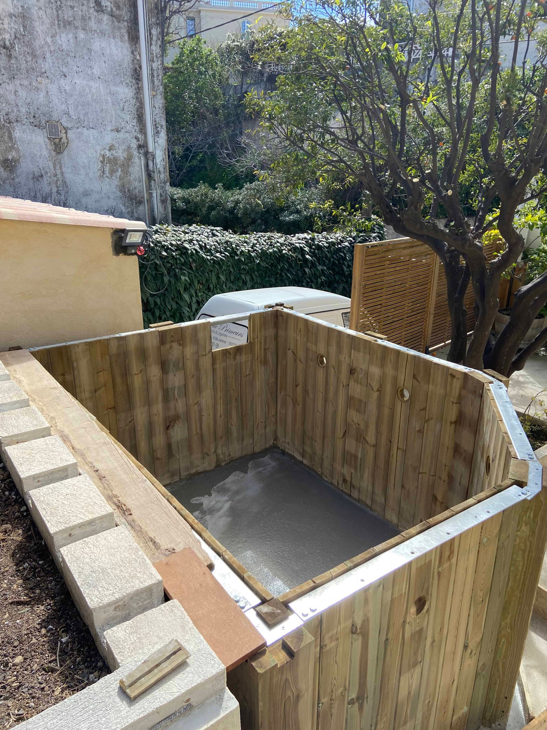 Un hangar en bois est en cours de construction dans une cour.